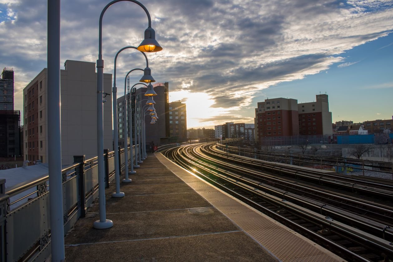 Light rail platform with lamp posts and tracks at sunset